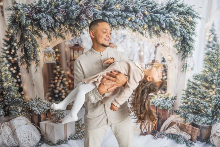 Père tenant sa fille sous décor de Noël