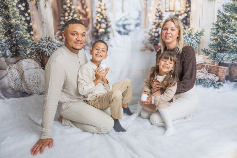 Famille posant devant décor de Noël enneigé