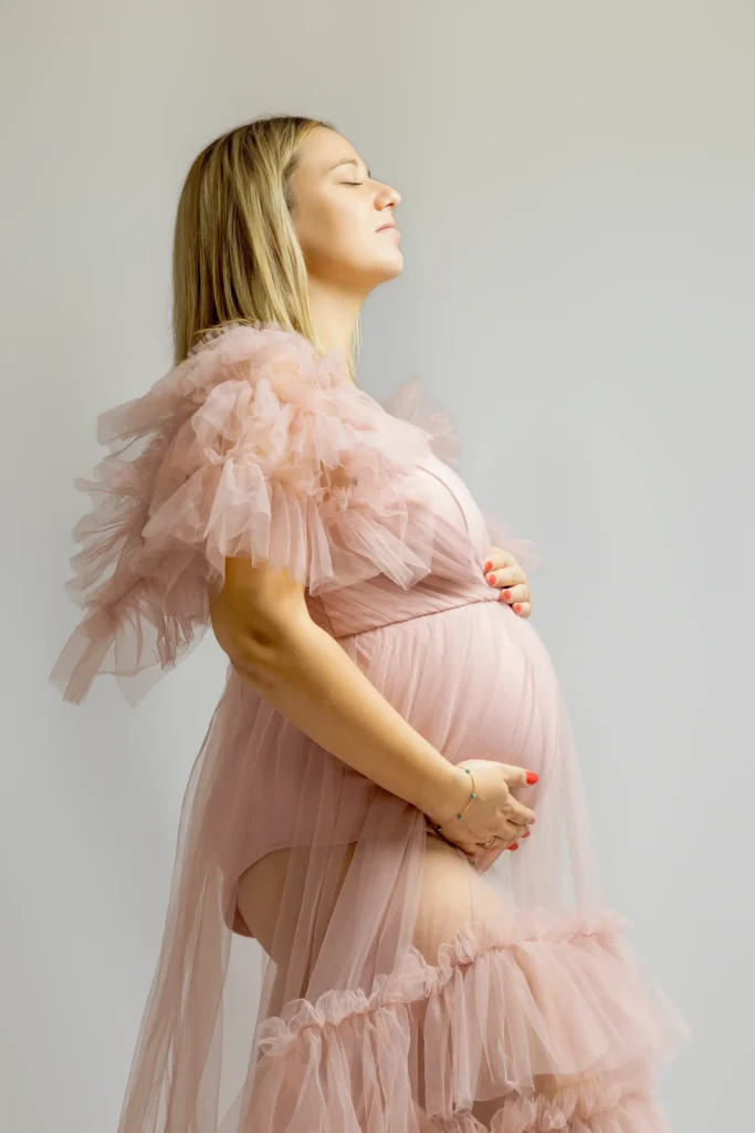 Femme enceinte en robe rose de tulle