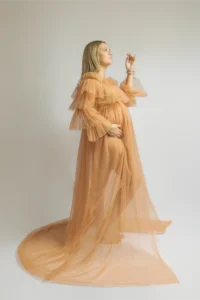 Femme enceinte en robe de tulle pêche