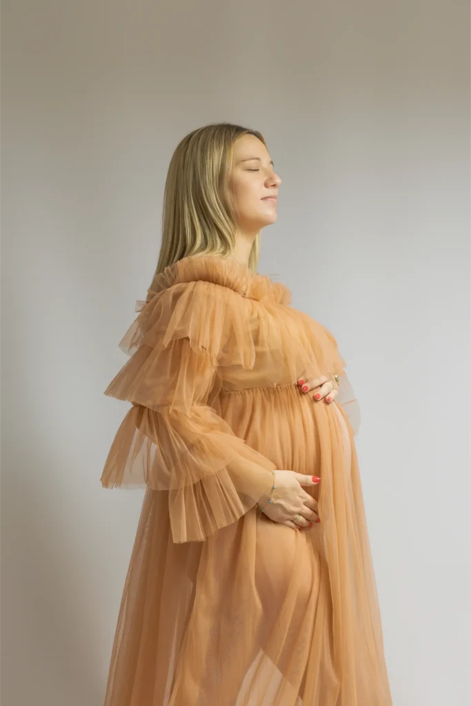 Femme enceinte en robe de tulle beige