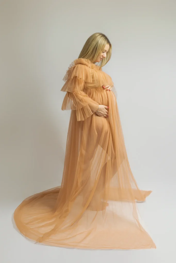 Femme enceinte en robe de tulle couleur pêche – séance grossesse en studio à Ancenis