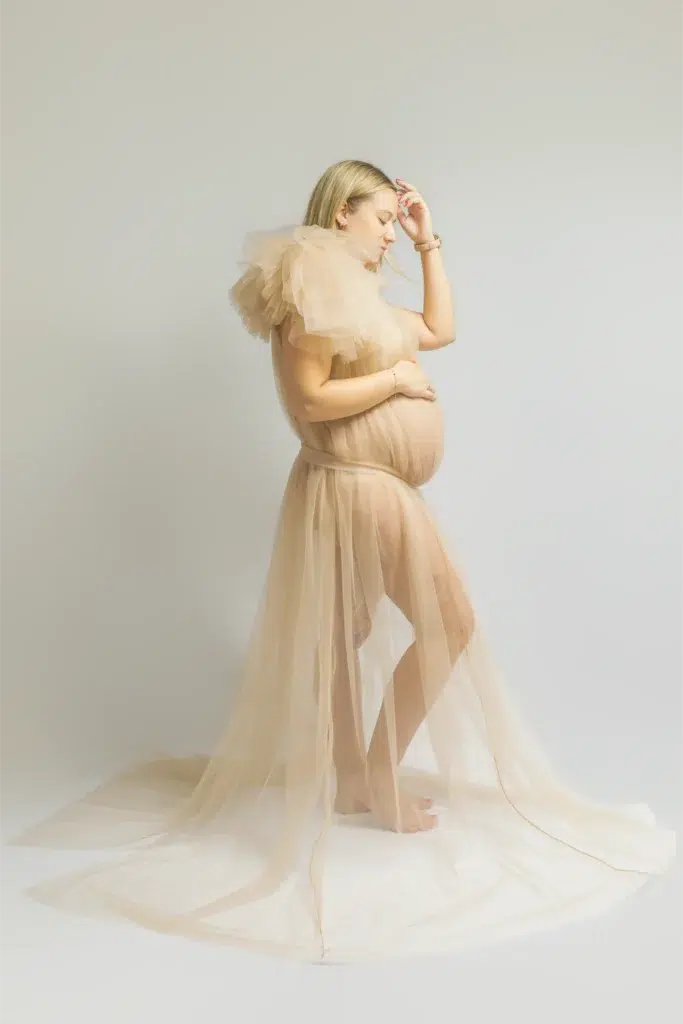 Femme enceinte en robe de tulle beige