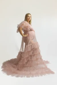 Femme enceinte en robe rose vaporeuse à volants