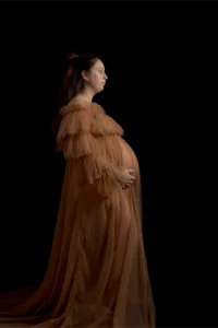 Femme enceinte en robe de tulle sur fond noir