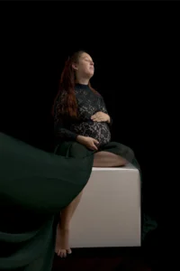 Femme enceinte assise, mains posées sur son ventre