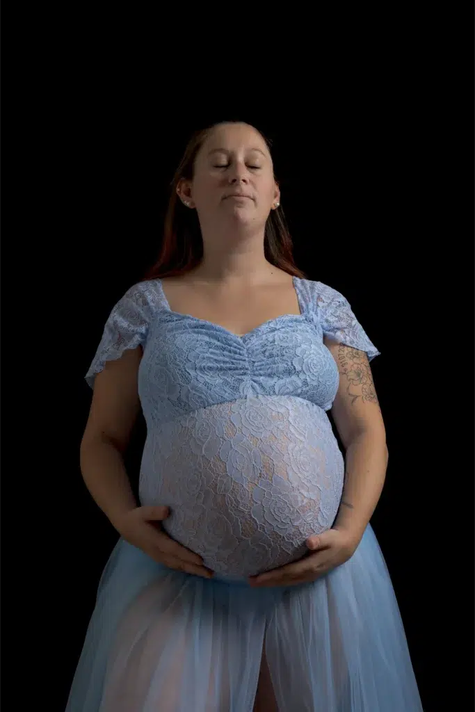 Femme enceinte en robe bleue, yeux fermés – séance grossesse en studio à Ancenis