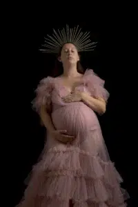 Femme enceinte en robe rose avec halo doré