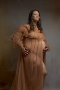 Femme enceinte en robe de tulle, yeux fermés