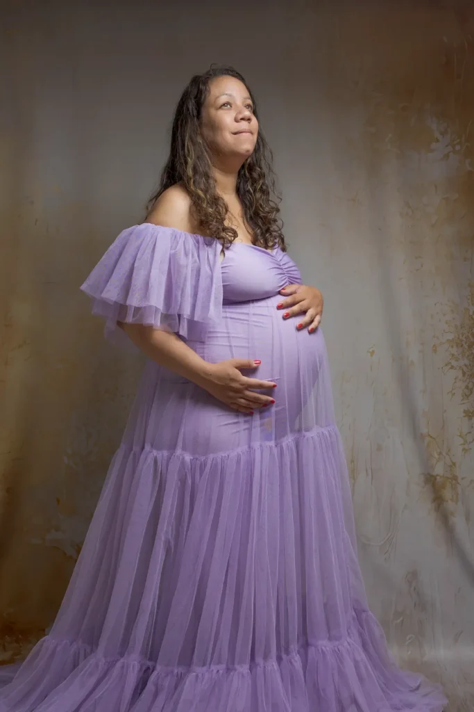 Femme enceinte en robe lavande posant de profil