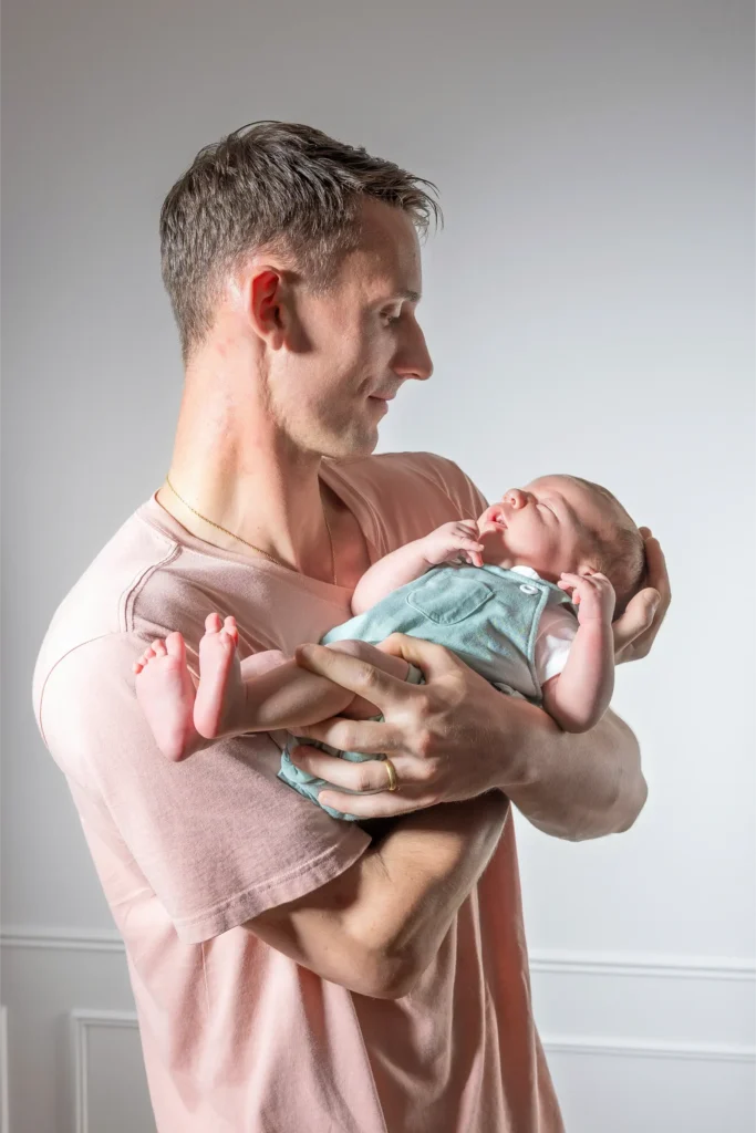 Père tenant tendrement son nouveau-né dans ses bras