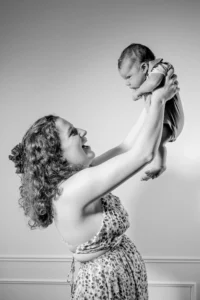 Mère souriante levant son bébé dans les bras