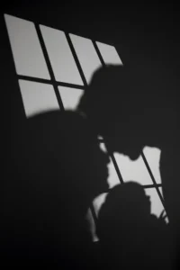 Ombres de personnes projetées sur une fenêtre éclairée