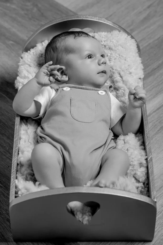 Bébé éveillé dans un berceau en bois
